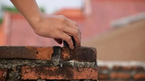 Metal weighing scale placed on brick rooftop wall by man's hand Stock Footage 312055237