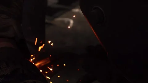 Metal welder working with arc welding machine to weld steel at factory while Stock Footage 320290032