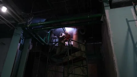 Metal welding in darkness under the ceiling shooting from below Stock Footage 229699041