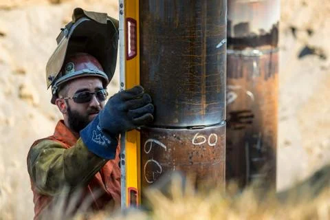 Metal worker aligning piling to be welded Stock Photos