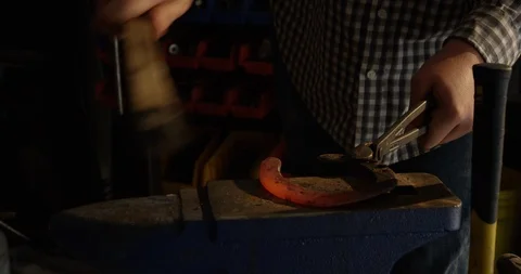 Metal worker brushing prepping red hot horseshoe Stock-Footage 120441790