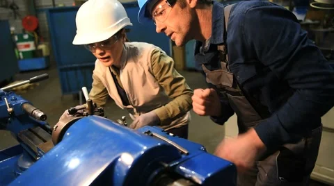 Metal worker teaching trainee on machine use Stock Footage 59779126