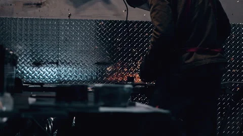 Metal worker welding in dark work shop - high contrast slow motion Stock Footage 168464045