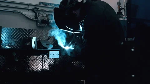 Metal worker welding in dark work shop - high contrast slow motion Stock Footage 168464169