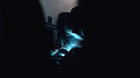 Metal worker welding in dark work shop - high contrast slow motion Stock Footage 168464244