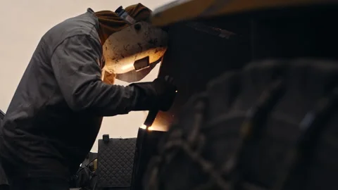 Metal worker welding in dark work shop - high contrast slow motion Stock Footage 168464728
