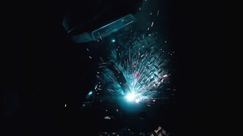 Metal worker welding in dark work shop - high contrast slow motion Stock Footage 168464905