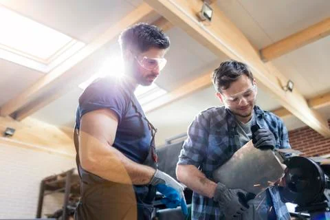 Metal workers using sander in workshop Stock Photos