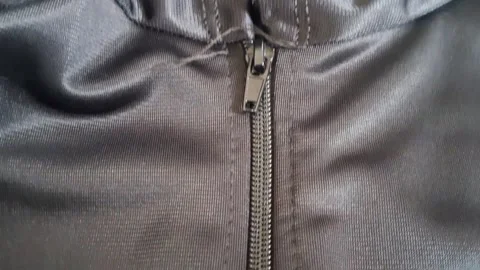 Metal zipper sliding down on dark grey athletic jacket motion footage Stock Footage 339248290