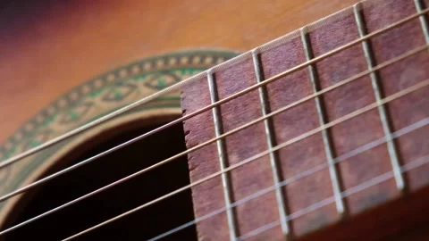 Metalic strings vibrating on classical acoustic guitar when musician playing 스톡 동영상 219575612