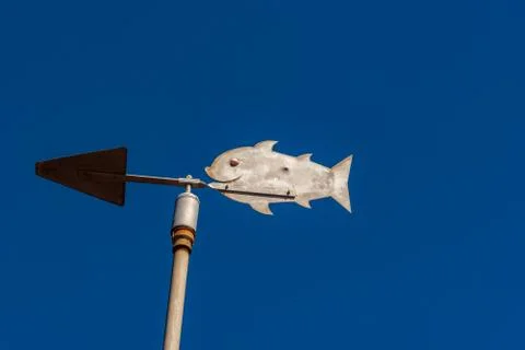 Metalic vane with the shape of a fish with a clean blue sky background Stock Photos