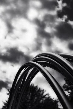 Metallic Archways Under a Dramatic Cloudy Sky in Black and White Stock Photos