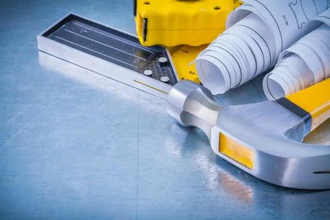 Metallic background with construction plans claw hammer square ruler and Stock Photos