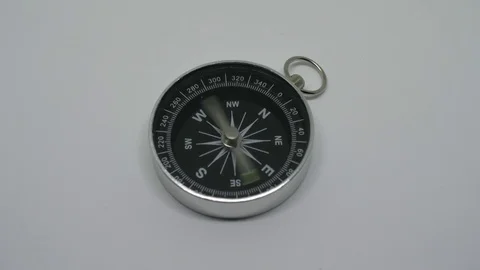 Metallic compas spinning and pointing south east on a white background Stock Footage 81599271
