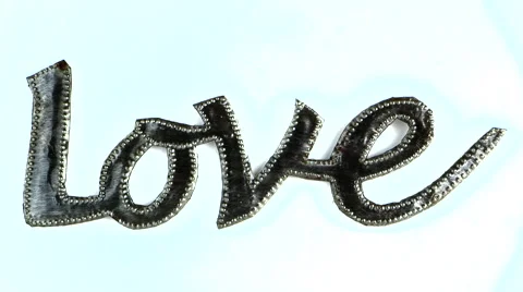 Metallic cursive word "Love" focus pull Stock Footage 49758806