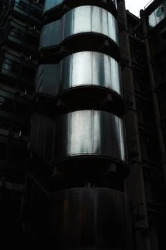 Metallic cylindrical structures on modern building facade Stock Photos