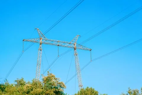 Metallic electrical tower transmitting high voltage. Energy industry Stock Photos