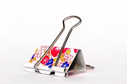 A metallic flower patterned paper clip, isolated on a white background Stock Photos