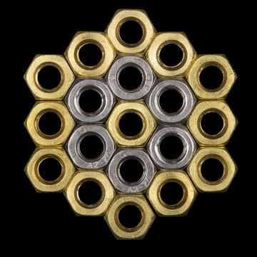 Metallic hex nuts layed out in a hexagonal pattern isolated on black backgrou Stock Photos