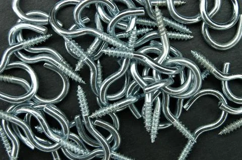 Metallic hook screws on a dark background. Stock Photos