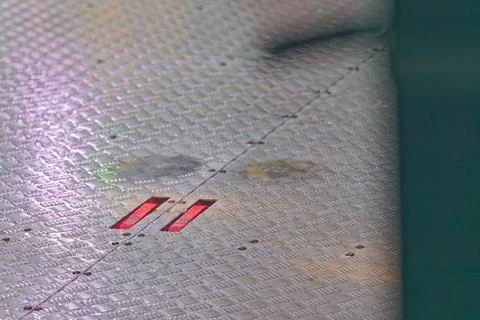 Metallic industrial floor with textured pattern and red illuminated rectang.. Stock Photos