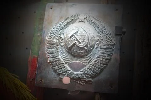 A metallic plaque featuring the Coat of Arms of the Soviet Union. The emblem  Stock Photos