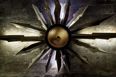 Metallic radial star-shaped sculpture with dramatic lighting 스톡 사진