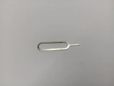 Metallic SIM card tray ejector pin tool on white background Stock Photos