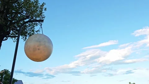 Metallic sphere on a black pole under a tree. 스톡 동영상 347457503