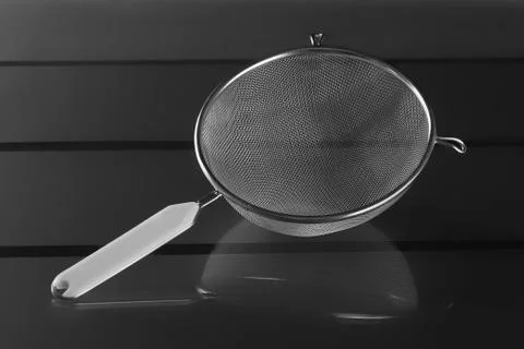 Metallic strainer with plastic handle, a modern kitchen utensil Photos