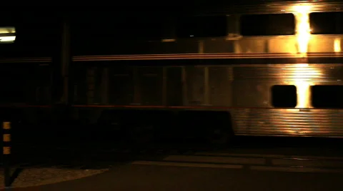 Metallic train passes by at night Stock Footage 706996