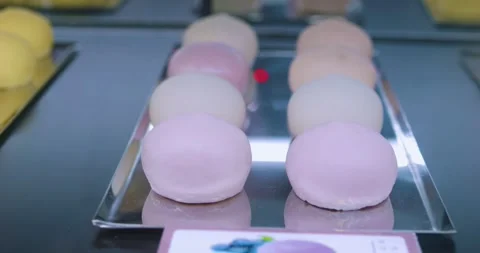 Metallic tray displaying rows of mango mochi, one slice revealing bright yellow Video stock 302859909