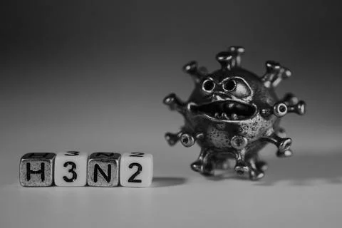 Metallic virus model with exaggerated features beside lettered blocks spell.. Stock Photos