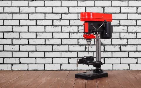 Metalwork tool - Red new drill press white brick wall background Stock Photos