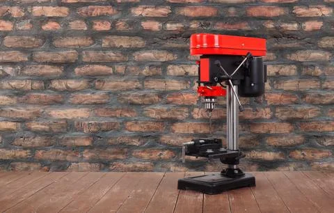Metalwork tool - Red new drill press brick wall background Stock Photos