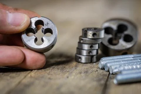 Metalwork tools on the workshop table. Threading dies and taps in an old dust Stock Photos