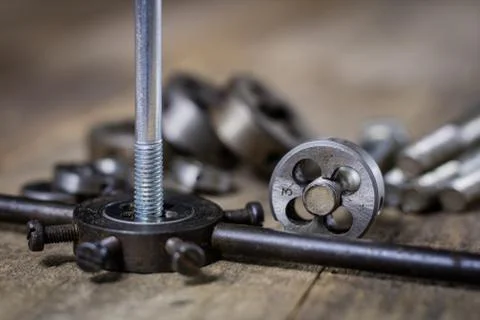 Metalwork tools on the workshop table. Threading dies and taps in an old dust Stock Photos