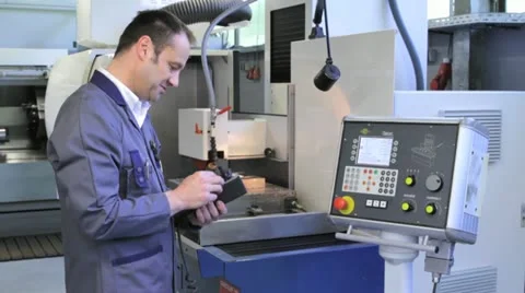 Metalworker operates CNC machine - 2 Stock Footage 11899835