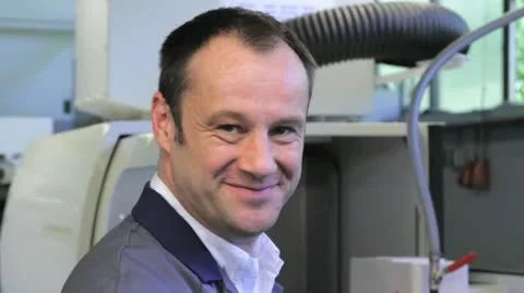 Metalworker operates CNC machine - looks into the camera - 2 Stock-Footage 11899883