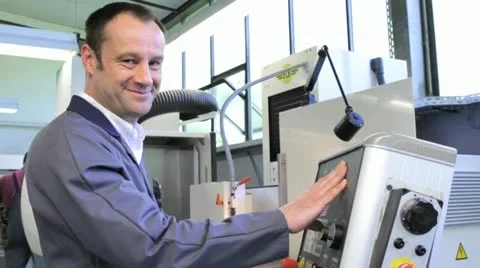 Metalworker operates CNC machine - looks into the camera - 9 Video stock 11899898