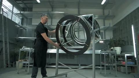 Metalworker in a protective apron sets ready-made structures Stock Footage 179699462