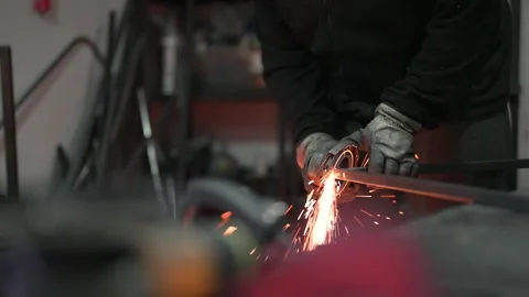 Metalworker using grinder tool with sparks flying during fabrication Stock Footage 308829109