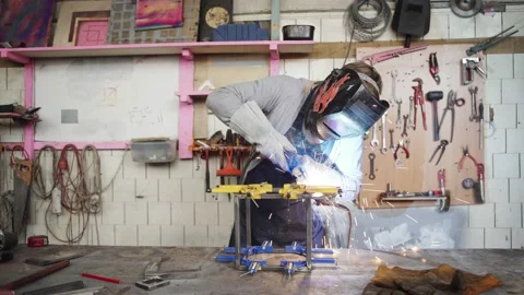 Metalworker welding metal cube at workbench Stock Footage 142335154