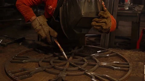 A metalworker welds an element of a metal structure with electric welding. Stock Footage 136356774