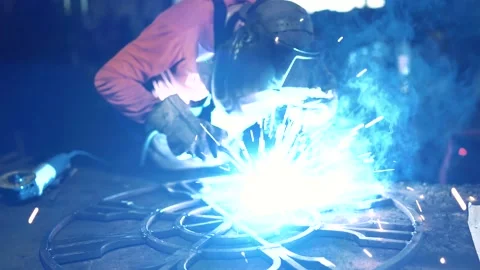 A metalworker welds an element of a metal structure with electric welding. Stock Footage 136356846
