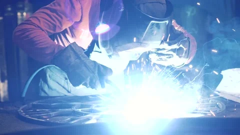 A metalworker welds an element of a metal structure with electric welding. Stock Footage 136357686