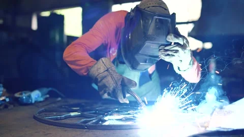 A metalworker welds an element of a metal structure with electric welding. Stock Footage 136357725