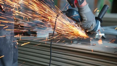Metalworking with a hand-held circular saw, close up, the disk is blurred in Stockbeeldmateriaal 128496873