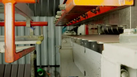 Metalworking. A special machine cuts the sheets of metal tiles. Close up. Metal Stock Footage 197384160