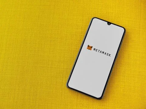 MetaMask app launch screen on smartphone on yellow fabric background Stock Photos